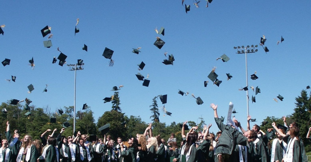 Students throwing their hats off the air in graduation